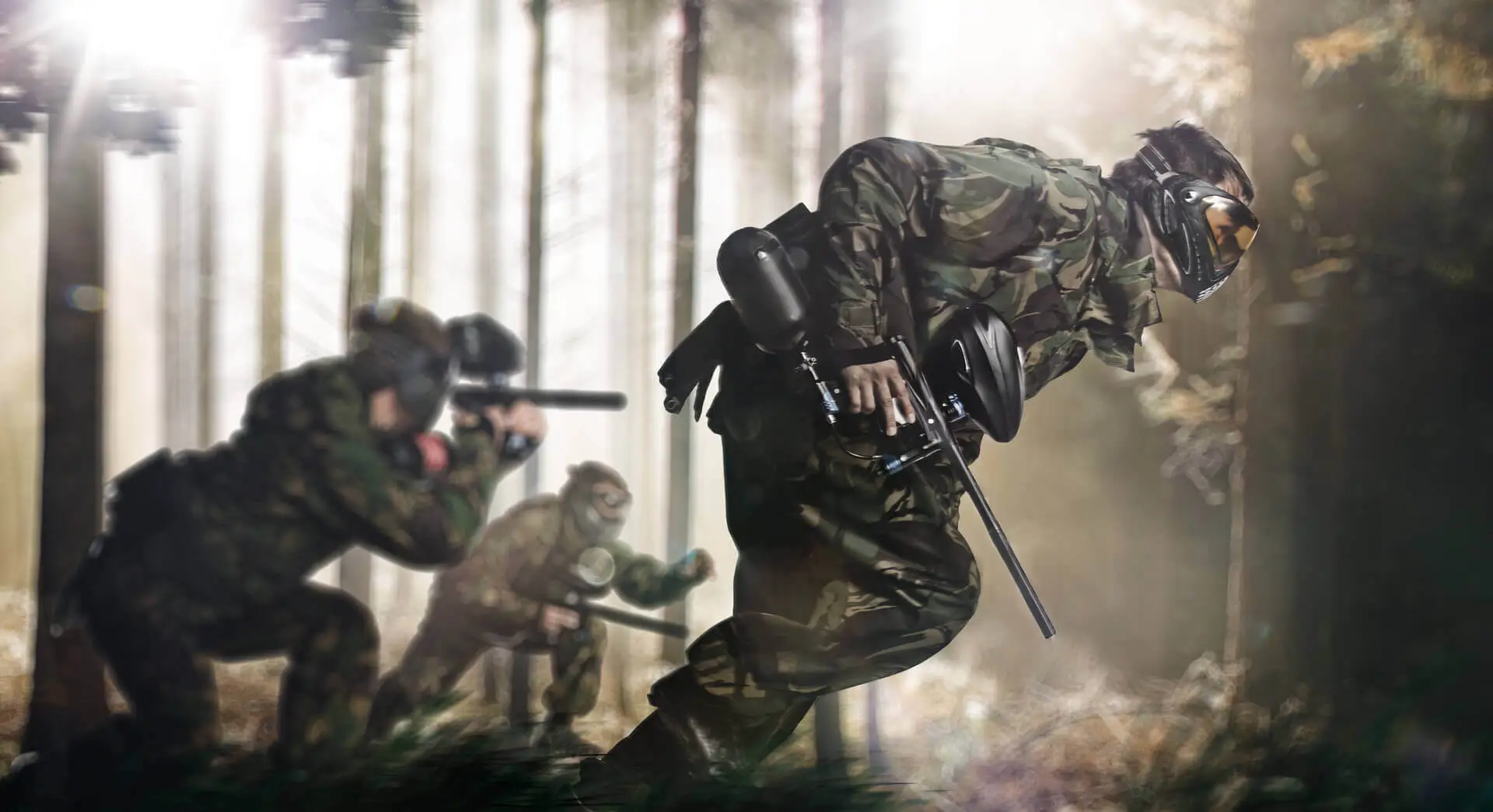 paintball players in a forest running
